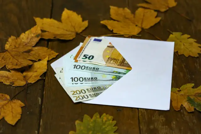 Koperta z euro na chrzciny, wśród jesiennych liści. Ile daje się na chrzciny? Pieniądze na prezent.