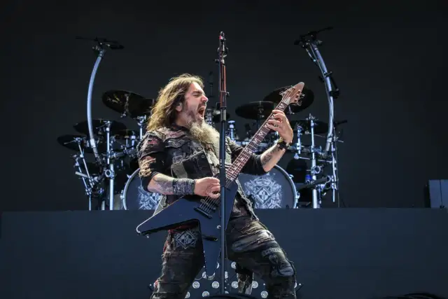 Robb Flynn z Machine Head na jednym z koncertów, w pełni energii, szaleje na czarnej gitarze typu V.