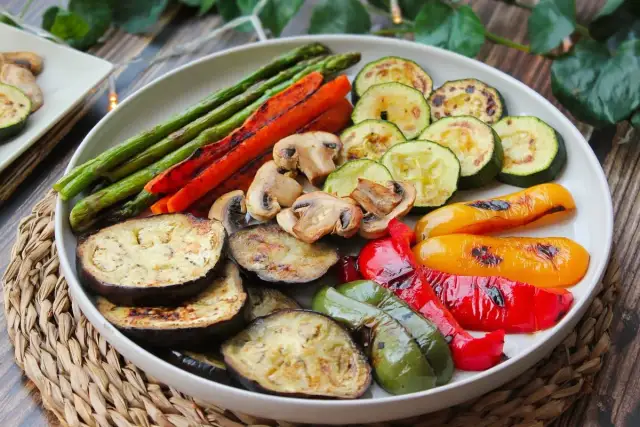 Una colorida parrillada de verduras: espárragos, zanahorias, champiñones, calabacín, berenjena y pimientos asados a la perfección.