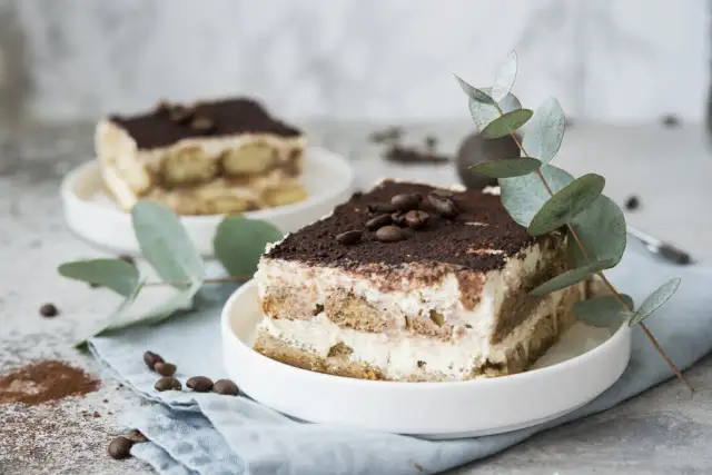Pyszne tiramisu z serka mascarpone, udekorowane kawą i gałązką eukaliptusa. Idealny deser, gdy zastanawiasz się, co zrobić z serka mascarpone.