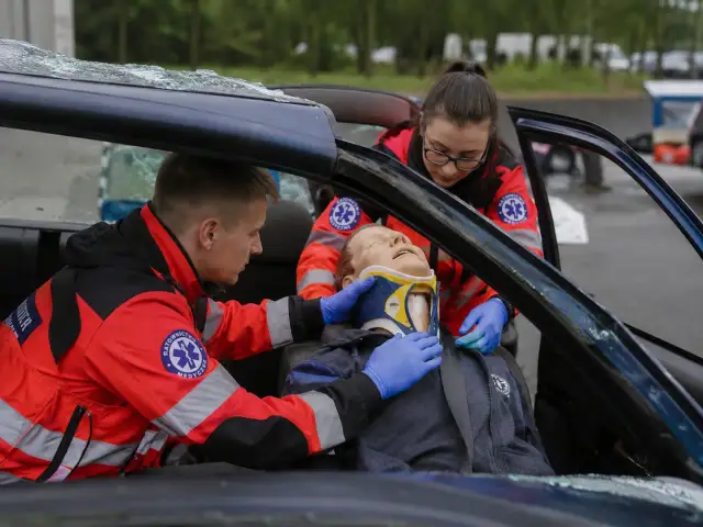 Ratownicy medyczni ćwiczą pomoc poszkodowanemu w wypadku samochodowym. To ważny krok, jak zostać ratownikiem medycznym.