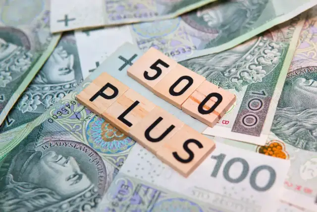 Litery "500 PLUS" na tle polskich banknotów. Symbol wsparcia finansowego, np. 500 plus dla niepełnosprawnych.