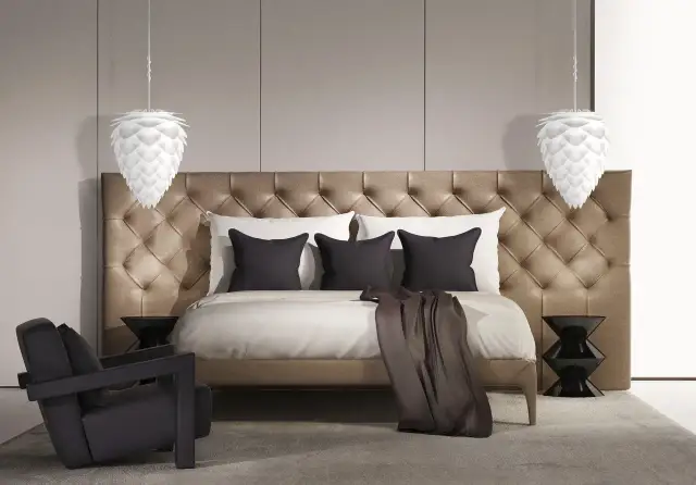 Elegancka lampa sufitowa do sypialni w kształcie szyszki, wisząca nad luksusowym łóżkiem z pikowanym zagłówkiem.