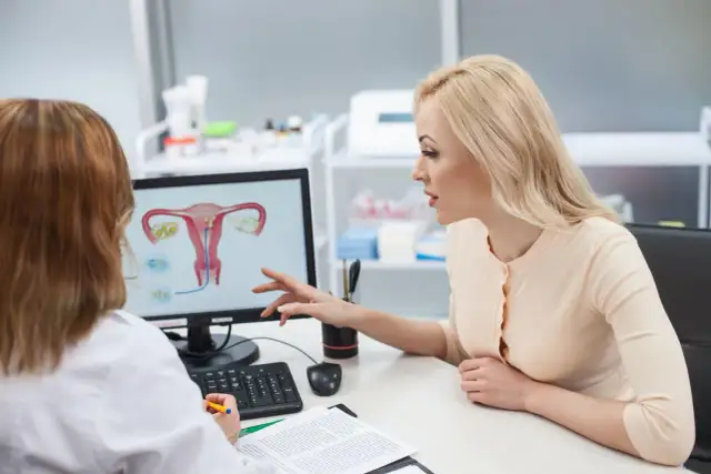 Pacjentka omawia z lekarką anatomię układu rozrodczego, planując zmianę lekarza prowadzącego ciążę.