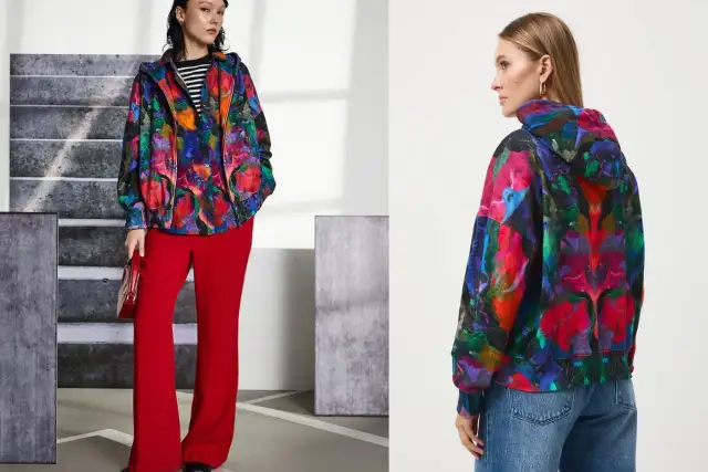 Kolorowe bluzy damskie XXL z abstrakcyjnym wzorem. Jedna modelka w czerwonych spodniach, druga w jeansach.