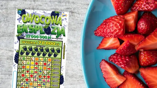Zdrapka "Owocowa Ekspozycja" z motywem owoców i szansą na wygraną 70 000 zł. Obok talerz pełen soczystych truskawek.