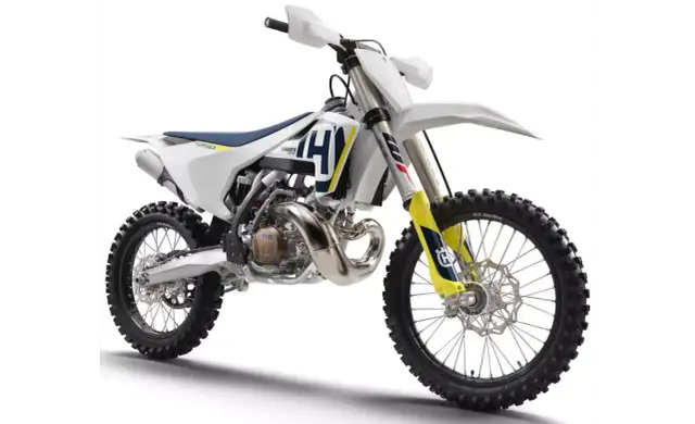 Nowy motocykl cross Husqvarna 250 gotowy na wyzwania toru. Biało-niebiesko-żółte malowanie, potężny silnik i terenowe opony.