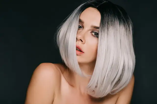 Kobieta z czarnymi włosami przechodzącymi w modny ombre blond.