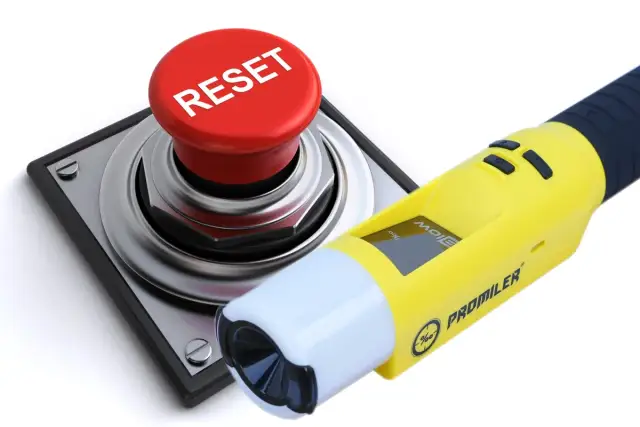 Żółty alkomat Promiler obok czerwonego przycisku RESET.
