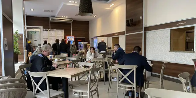 Ludzie jedzą w barze mlecznym, szukając dobrego jedzenia w Warszawie.