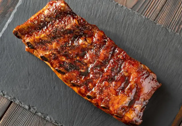 Costillas al horno con miel y mostaza, glaseadas y jugosas, listas para disfrutar.