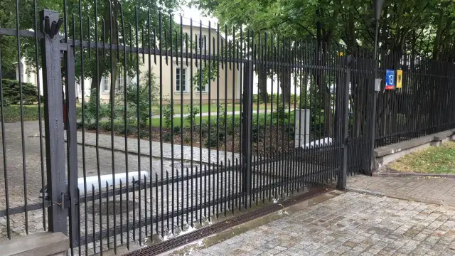 Widoczny mechanizm to jaki napęd do bramy dwuskrzydłowej, zamontowany na jednym ze skrzydeł.