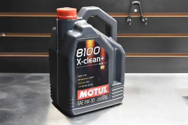 Czarna bańka oleju silnikowego Motul 8100 X-clean+ 5W-30 z czerwonym korkiem.