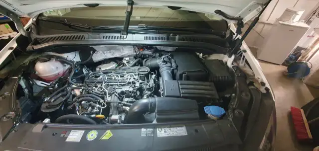 Motorraum eines VW Golf 7 1.6 TDI mit geöffneter Motorhaube.
