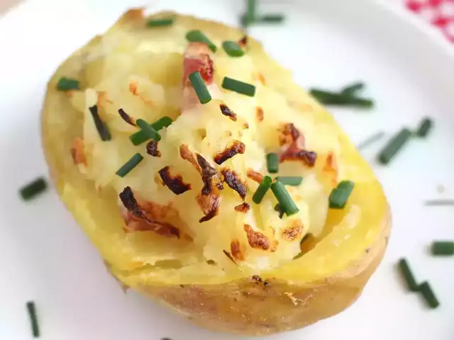 Patatas al horno con queso y bacon, gratinadas y espolvoreadas con cebollino fresco. ¡Un bocado delicioso!