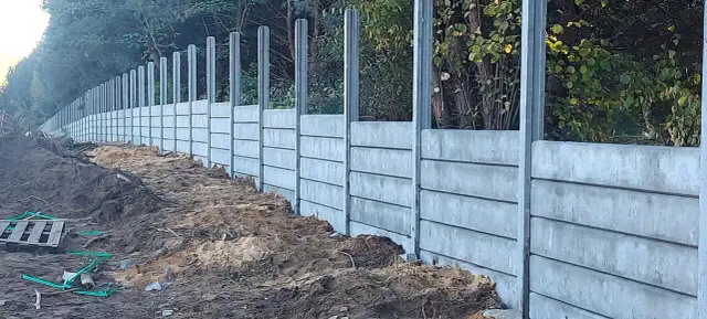 Budowa ogrodzenia z betonowych płyt i słupków. Takie słupki betonowe to solidna podstawa.