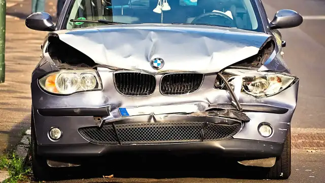 Uszkodzony BMW po wypadku. Zderzak, maska i reflektory są zniszczone. Wygląda na to, że czeka go szkoda całkowita, mimo że był w leasingu.