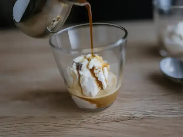 Gorące espresso zalewa gałkę lodów waniliowych, tworząc pyszne affogato.