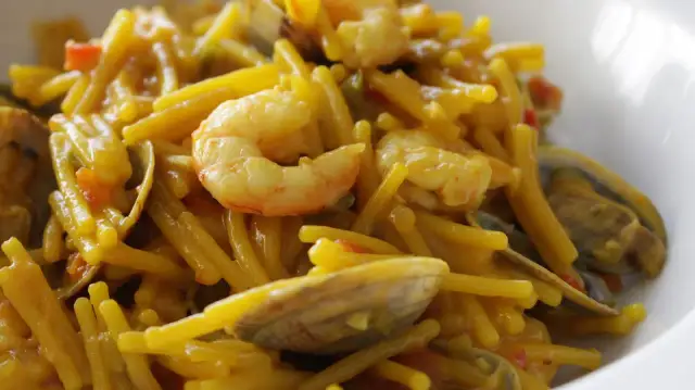 Fideos con almejas y gambas, un plato de marisco delicioso y lleno de sabor.