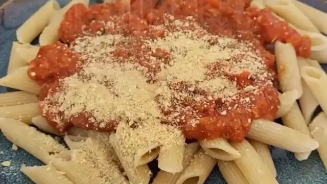 Penne mit Tomatensauce und veganem Parmesan bestreut. Ein köstliches, pflanzliches Gericht.