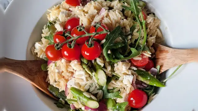 Leckerer Nudelsalat mit Spargel, Kirschtomaten, Feta und Rucola. Ein frischer Genuss!