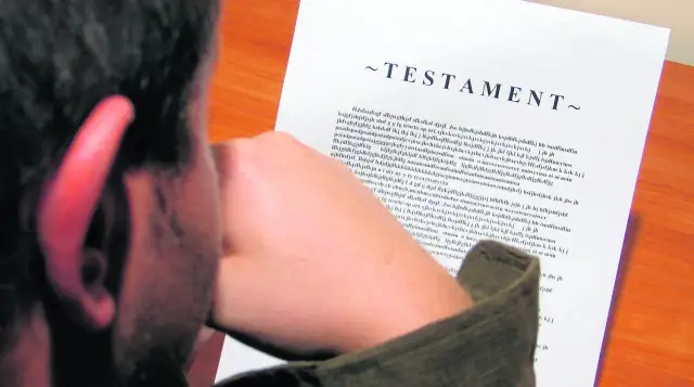 Mężczyzna pochyla się nad dokumentem z napisem "~TESTAMENT~".