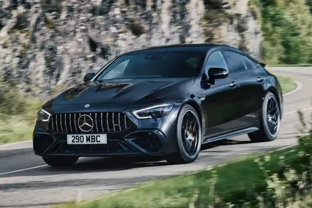 Czarny Mercedes-AMG GT 63 S na zakręcie górskiej drogi.