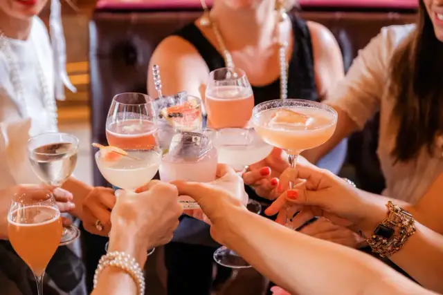 Kobiety wznoszą toast kolorowymi drinkami. Zastanawiasz się, ile kalorii ma drink?