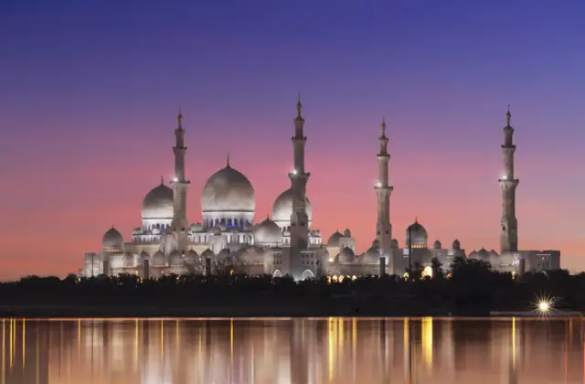 Wspaniały meczet oświetlony nocą, odbijający się w wodzie. Idealny widok, kiedy jest Ramadan.