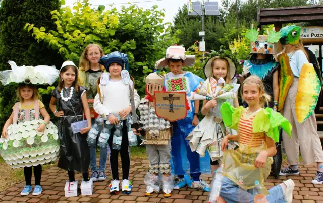 Dzieci prezentują stroje ekologiczne z recyklingu: z kubeczków, folii, butelek i gazet. Pomysł na to, jak zrobić strój ekologiczny.