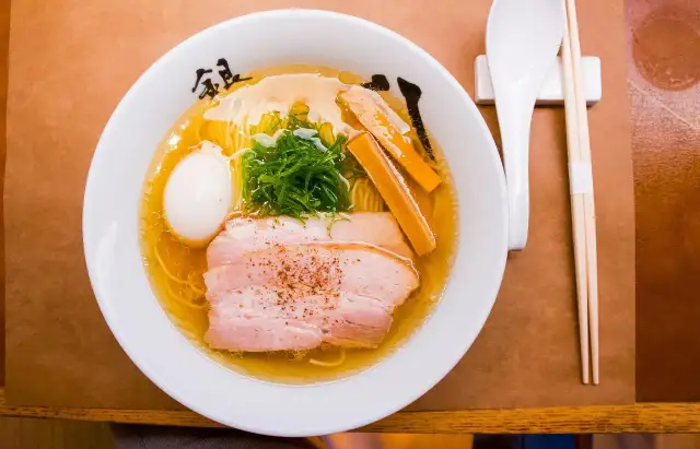 Misternie przygotowane ramen z plastrami wieprzowiny, jajkiem i szczypiorkiem. Zastanawiasz się, ile kalorii ma ramen?