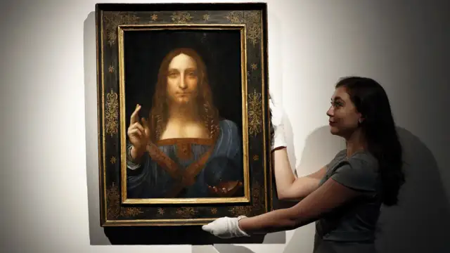 Frau mit weißen Handschuhen präsentiert das Gemälde "Salvator Mundi" von Leonardo da Vinci.