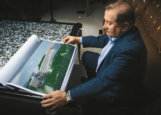 Henryk Gołębiewski, właściciel hoteli, ogląda projekt nowoczesnego hotelu zlokalizowanego nad wodą.