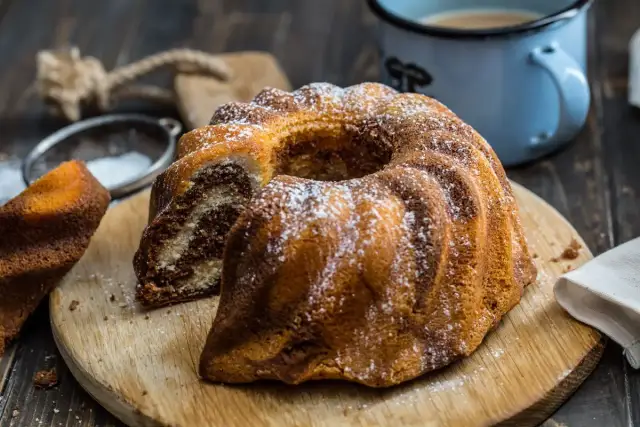 Pyszna babka piaskowa dwukolorowa, oprószona cukrem pudrem, czeka na kawę.