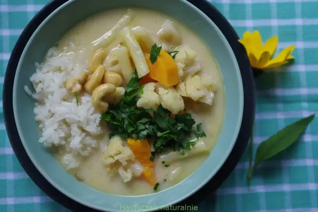 Aksamitny kremowy sos z ryżem, kalafiorem, orzechami nerkowca i marchewką. Pyszne danie inspirowane smakami tajskiej kuchni, przypominające **pasta tom kha**.