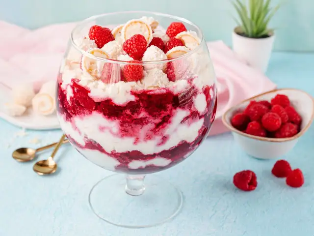Raffaello Himbeer Dessert im Glas mit frischen Himbeeren und Kokosflocken.