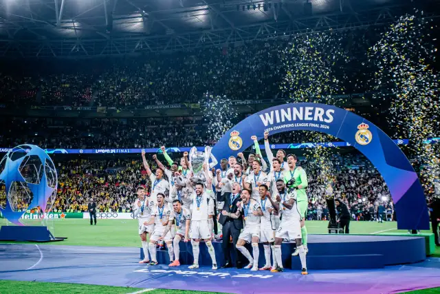 Piłkarze Realu Madryt świętują zwycięstwo w Lidze Mistrzów 2024, podnosząc trofeum wśród konfetti.