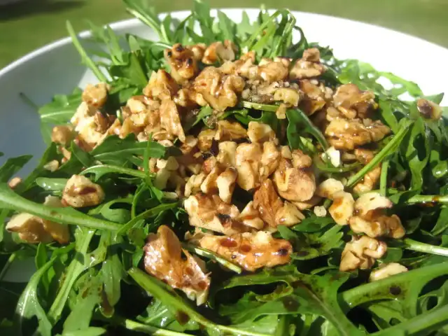 Ensalada de rucula fresca con nueces tostadas y un glaseado balsámico. Un plato ligero y sabroso.