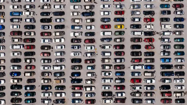 Wiele samochodów różnych marek na parkingu.