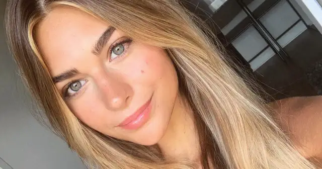 Uśmiechnięta dziewczyna z zielonymi oczami i włosami w odcieniu sombre blond.