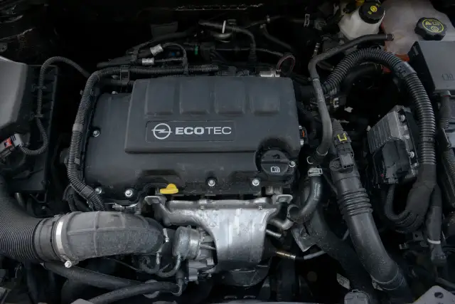 Silnik samochodowy Opel Ecotec z widocznymi przewodami i elementami.