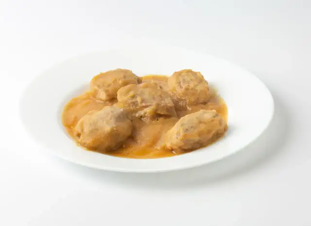Solomillo de cerdo con manzana en salsa, servido en un plato blanco.