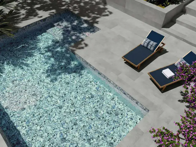Modernas ideas de piscinas: piscina con mosaico azul brillante, tumbonas y flores moradas.