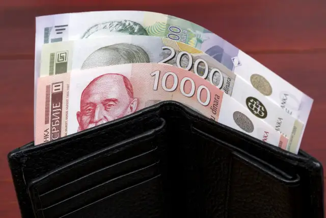 Czarny portfel wypełniony banknotami serbskie dinary. Widać nominały 1000 i 2000.