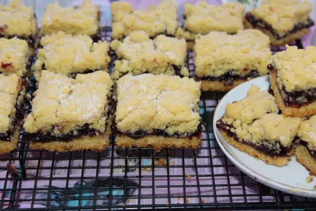 Puszyste ciasto z owocami bez jajek, pokrojone w kostkę, z kruszonką i dżemem.