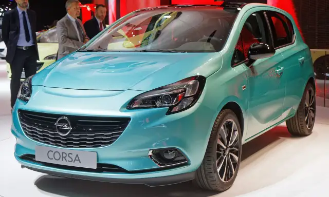 Türkisfarbener Opel Corsa mit Schriftzug "Corsa" auf dem Kühlergrill.