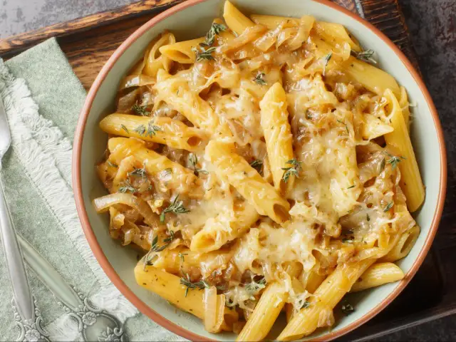 Penne z karmelizowaną cebulą i serem zapieczone w piekarniku. Szybki pomysł na obiad, co można zrobić w piekarniku na szybko.