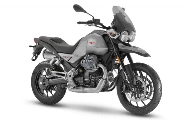 Srebrny motocykl Moto Guzzi V85 TT z charakterystycznym silnikiem V-twin, gotowy na przygodę.