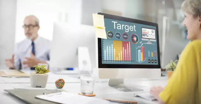 Kobieta analizuje wykresy na ekranie komputera, planując kampanię reklamową w internecie.