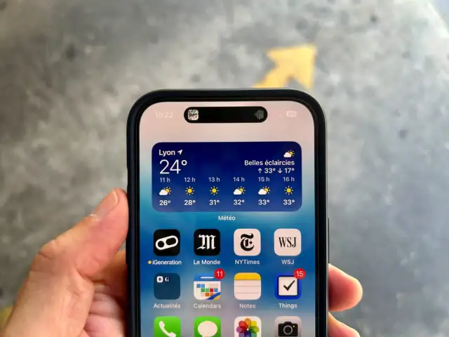 iPhone avec la Dynamic Island affichant la météo à Lyon. La barre d'état montre l'heure et le niveau de batterie.